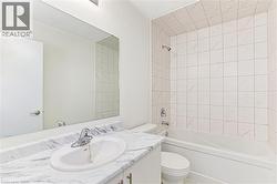 Full bathroom featuring a white vanity with a marble-patterned countertop, an oval undermount sink, and a large wall-mounted mirror - 