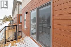 Sliding glass door leading to an outdoor deck with glass panel railings - 
