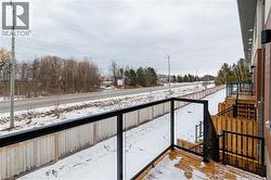 Wood-finish decking with black metal and glass railing system - 