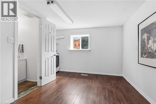 Spacious room featuring wood-finish flooring, white baseboards, and a window providing natural light - 137 Market Street, Hamilton, ON - Indoor Photo Showing Other Room