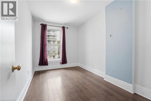 Bright room featuring wood-finish flooring, a double-hung window, and a light fixture - 137 Market Street, Hamilton, ON - Indoor Photo Showing Other Room