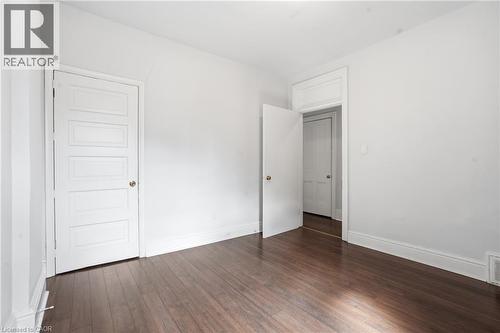 Interior room featuring dark wood-finish flooring, white walls, and white trim - 137 Market Street, Hamilton, ON - Indoor Photo Showing Other Room