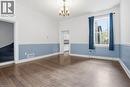 Spacious interior featuring wood-finish flooring, a decorative ceiling medallion with an attached chandelier, and a large window providing natural light - 137 Market Street, Hamilton, ON  - Indoor Photo Showing Other Room 
