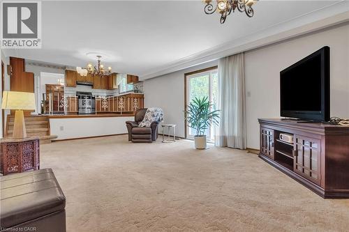 Open-concept living space featuring carpet flooring, a tiered ceiling, and a sliding glass door - 2344 Brinell Avenue, Burlington, ON - Indoor Photo Showing Living Room