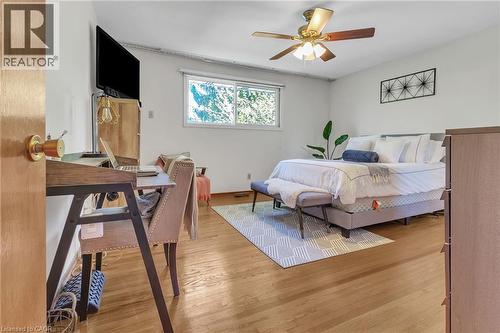 Light-filled room featuring wood-finish flooring, a window offering natural light, and a ceiling fan with integrated lighting - 2344 Brinell Avenue, Burlington, ON - Indoor Photo Showing Bedroom
