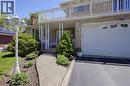 Stone veneer exterior with an integrated garage, upper-level balcony, and a paved driveway - 2344 Brinell Avenue, Burlington, ON  - Outdoor With Balcony 