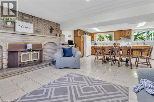Expansive stone fireplace with a wood-burning insert and a tiled hearth - 2344 Brinell Avenue, Burlington, ON - Indoor With Fireplace