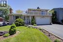 Split-level residence featuring a brick facade, integrated two-car garage, and a second-story balcony with white railing - 2344 Brinell Avenue, Burlington, ON  - Outdoor With Balcony 