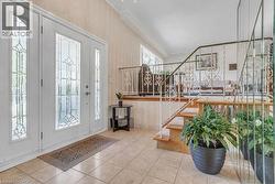 Entryway featuring an ornate double door with sidelights, decorative frosted glass, and light-toned tile flooring - 
