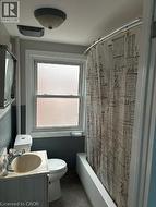 Bathroom with vanity, shower / tub combo with curtain, and tile patterned flooring - 
