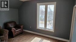 Sitting room with light wood-style floors and vaulted ceiling - 