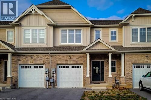 Townhome facade featuring brick and siding construction, a covered porch with white columns, and multiple windows - 111 Alicia Crescent, Thorold, ON 
