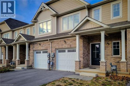 Brick and siding exterior featuring a covered front porch with white columns, a black front door, and an attached two-car garage with white paneled doors - 111 Alicia Crescent, Thorold, ON 