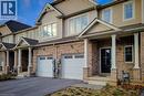 Brick and siding exterior featuring a covered front porch with white columns, a black front door, and an attached two-car garage with white paneled doors - 111 Alicia Crescent, Thorold, ON 