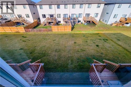 Expansive backyard featuring a large grass area, wood privacy fencing, and a multi-level wood deck with stairs - 111 Alicia Crescent, Thorold, ON 