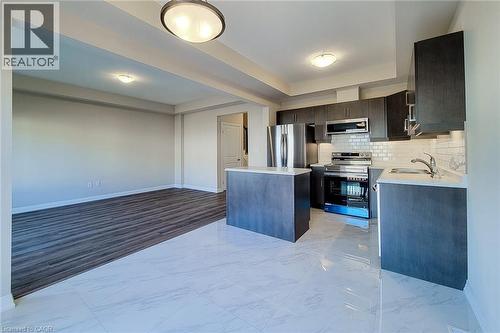 Contemporary kitchen with dark wood-finish cabinetry, stainless steel appliances, and a subway tile backsplash - 111 Alicia Crescent, Thorold, ON 