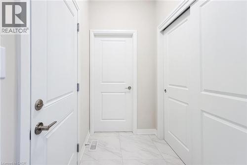 Hallway featuring light-toned walls, white trim, and white panel doors - 111 Alicia Crescent, Thorold, ON 