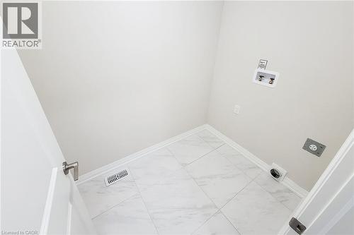 Dedicated utility room featuring white tile flooring, neutral wall paint, and white baseboards - 111 Alicia Crescent, Thorold, ON 