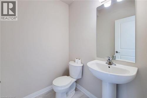 Pedestal sink with chrome faucet, wall-mounted mirror, and overhead vanity lighting - 111 Alicia Crescent, Thorold, ON 