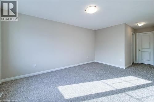 Spacious room with light gray walls, gray carpet, white trim, and two flush-mount ceiling lights - 111 Alicia Crescent, Thorold, ON 
