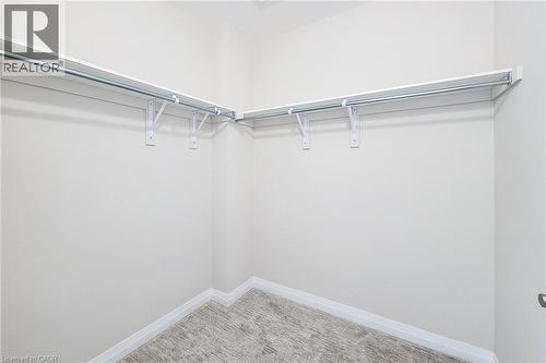 Walk-in closet featuring white wall shelving and integrated hanging rods - 111 Alicia Crescent, Thorold, ON 