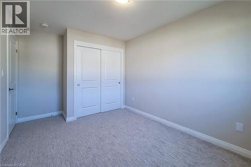 Room featuring light gray painted walls, a textured gray carpet, white trim work, and a white bi-fold closet door - 111 Alicia Crescent, Thorold, ON 