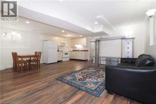 Open-concept living space featuring wood-finish flooring, recessed lighting, and a kitchen with white cabinetry and appliances - 67 Hollyridge Crescent Unit# Lower, Kitchener, ON - Indoor Photo Showing Living Room