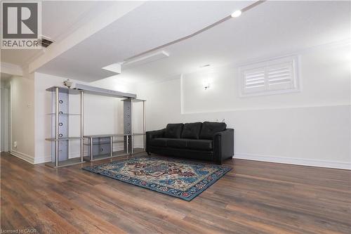 Spacious lower level featuring wood-finish flooring, recessed lighting, crown molding, and a window with white louvered shutters - 67 Hollyridge Crescent Unit# Lower, Kitchener, ON - Indoor