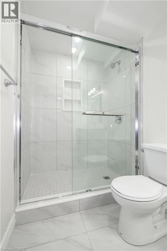 Glass-enclosed shower featuring white subway tile, a built-in shower niche, and a honeycomb-patterned shower pan - 67 Hollyridge Crescent Unit# Lower, Kitchener, ON - Indoor Photo Showing Bathroom