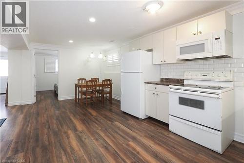 Kitchen featuring white cabinetry, subway tile backsplash, and dark wood-finish flooring - 67 Hollyridge Crescent Unit# Lower, Kitchener, ON - Indoor Photo Showing Kitchen