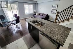 Kitchen island featuring a double basin stainless steel sink and granite-style countertop - 