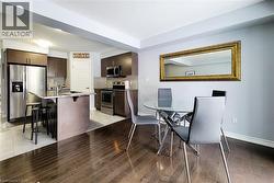 Open-concept dining area featuring wood-finish flooring, light grey walls, and a recessed ceiling - 