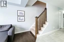 Staircase featuring wood railings and carpeted treads - 