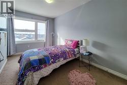 Carpeted room featuring light gray walls, a white window frame, and white baseboards - 