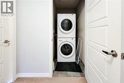 Dedicated laundry closet featuring a stackable washer and dryer unit - 
