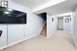Carpeted lower level with light gray walls and white trim - 
