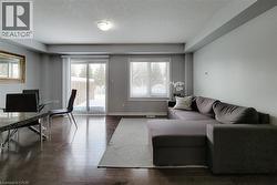 Open-concept living area featuring dark wood-finish flooring, light grey walls, and a recessed ceiling light fixture - 