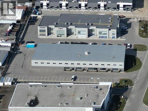Industrial building with a metal roof, multiple loading dock doors, and an expansive paved parking area - 44 Ditton Drive Unit# 3, Hamilton, ON 