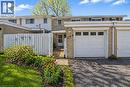 Front exterior featuring a single-car garage, light-toned brick facade, and a white picket fence - 104 Ralgreen Crescent, Kitchener, ON  - Outdoor 