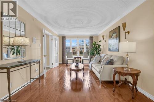 Spacious living area featuring wood-finish flooring, a decorative ceiling medallion, crown molding, and neutral wall tones - 228 Michener Crescent, Kitchener, ON - Indoor Photo Showing Living Room