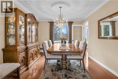 Formal dining area featuring hardwood flooring, a crystal chandelier, and a decorative ceiling medallion - 228 Michener Crescent, Kitchener, ON - Indoor Photo Showing Dining Room