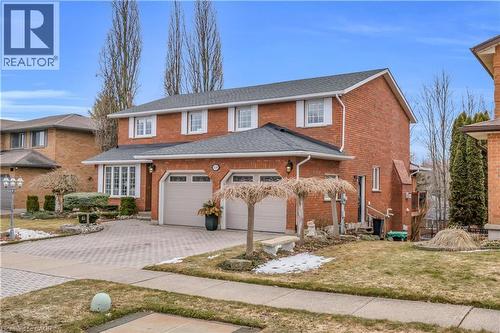 Brick two-story residence featuring a two-car garage with arched windows, a bay window with white framing, and a paved driveway - 228 Michener Crescent, Kitchener, ON - Outdoor