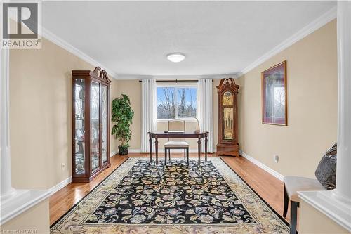 Neutral-toned interior room featuring wood-finish flooring, white baseboards, and crown molding - 228 Michener Crescent, Kitchener, ON - Indoor Photo Showing Other Room