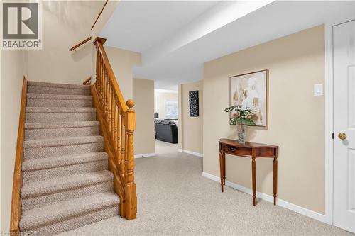 Carpeted staircase with wood banister and handrail, neutral wall tones, and white trim - 228 Michener Crescent, Kitchener, ON - Indoor Photo Showing Other Room