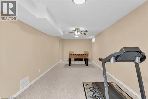Spacious recreation room featuring light-colored carpeting, neutral painted walls, and white baseboards - 228 Michener Crescent, Kitchener, ON - Indoor Photo Showing Gym Room