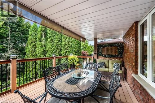 Covered outdoor deck featuring wood-finish flooring, a wood-tone railing with black balusters, and integrated lighting - 228 Michener Crescent, Kitchener, ON - Outdoor With Deck Patio Veranda With Exterior