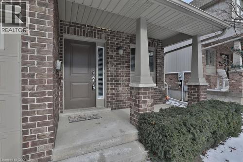 Brick facade residence featuring a covered front porch with substantial columns, a panel-style entry door with a vertical sidelight, and an integrated garage - 7 Gibson Place Unit# 21, St. Catharines, ON - Outdoor