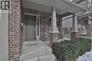 Brick facade residence featuring a covered front porch with substantial columns, a panel-style entry door with a vertical sidelight, and an integrated garage - 7 Gibson Place Unit# 21, St. Catharines, ON  - Outdoor 