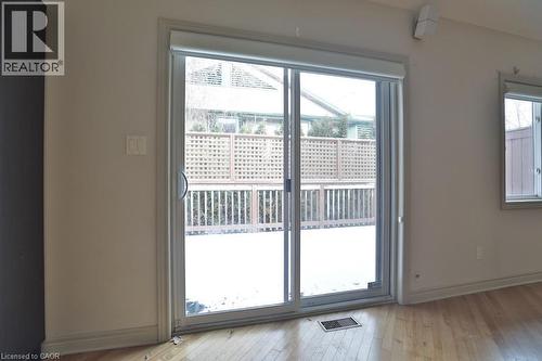 Sliding glass door leading to an outdoor deck with lattice privacy screening - 7 Gibson Place Unit# 21, St. Catharines, ON - Indoor Photo Showing Other Room