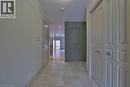 Hallway featuring tile flooring, paneled doors, recessed lighting, and a view into a room with wood-finish flooring and a balcony - 7 Gibson Place Unit# 21, St. Catharines, ON  - Indoor Photo Showing Other Room 